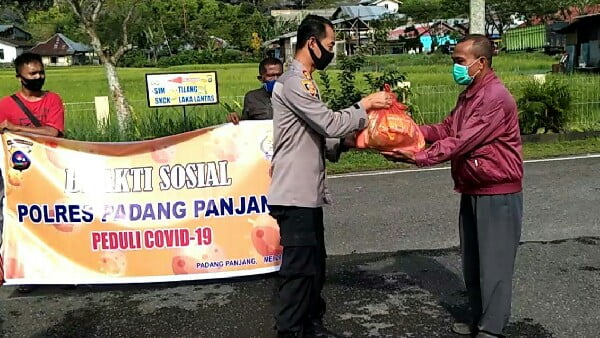 Kapolres Padang Panjang AKBP Sugeng Hariyadi, SIK, SH, MH menyerahkan paket sembako kepada salah seorang warga yang membutuhkan.
