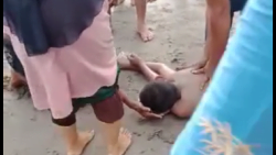 Warga memberi pertolongan pada warga yang terseret ombak di Pasir Jambak