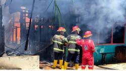 Petugas damkar berupaya menjinakkan sijago merah