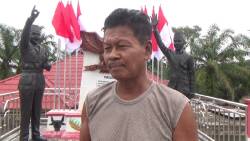 Winoto dengan latar patung Soekarno dan Jokowi