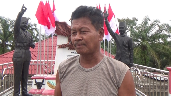 Winoto dengan latar patung Soekarno dan Jokowi