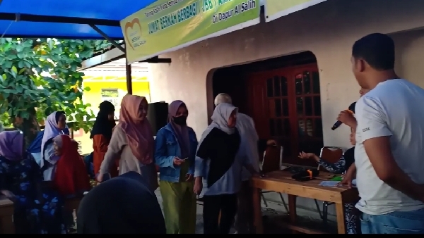 Para mustahiq menyerahkan kupon yang telah dibagikan untuk menerima zakat Muthia binti Amril