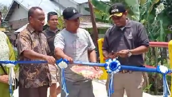 Lurah Banuaran Devrison didampingi Ketua RT 03 RW 01 dan Rusdi melakukan pemotongan pita saat peresmian jembatan