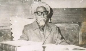 SPIRITSUMBAR.COM - Surau di Minangkabau, bukan sekadar bangunan kecil untuk shalat. Ia mesin pembentuk karakter dengan disiplin, hafalan, adab, dan jalan hidup yang bisa melampaui batas kampung. Dari ekosistem inilah lahir seorang anak bernama Ahmad Khatib, yang kelak namanya menempel pada dua dunia sekaligus, Minangkabau dan Makkah. Sumber resmi Kementerian Agama mencatat ia lahir di Koto Tuo, Balai Gurah, Kabupaten Agam , Sumatera Barat (Sumbar) pada Senin, 6 Zulhijah 1276 H/ 1860 M. Sebagaimana ditulis Lajnah Penta shihan Mushaf Al-Qur'an , Ahmad Khatib terlahir dari ayah Abdul Latif bin Abdullah dan ibu Limbak Urai binti Tuanku Nan Renceh. Abdul Latif berasal dari Koto Gadang sedangkan Limbak Urai dari Koto Tuo Balai Gurah. Sejak kecil, Ahmad Khatib menaruh minat besar pada ilmu dan ulama. Ia belajar membaca Al-Qur’an kepada ayahnya di sebuah maktab (lembaga belajar dasar) hingga usia kira-kira 11 tahun. Di usia yang bagi kita sekarang identik dengan kelas 5–6 SD, ia sudah berada di ambang keputusan hidup yang besar: pergi ke Makkah. Saat masih berusia 11 tahun pada 1287 H, Ahmad Khatib berangkat ke Makkah bersama ayahnya, kakeknya, dan pamannya, Abdul Gani. Ini bukan sekadar perjalanan ibadah, tapi semacam “beasiswa” zaman dulu—dibayar dengan keberanian keluarga dan daya tahan badan. Setelah menunaikan rangkaian haji, ada pola yang sering terjadi pada pelajar Nusantara, orang tua pulang, anak tinggal untuk menuntut ilmu. Dalam narasi Kemenag, Ahmad Khatib menetap di Makkah untuk belajar agama dan menghafal Al-Qur’an. Di Masjidil Haram, ia masuk ke tradisi *halaqah*—lingkaran belajar yang berjalan hampir tanpa henti.Guru membaca, menerangkan, murid menyimak, bertanya, lalu mengulang sampai paham. Nama-nama gurunya yang tercatat antara lain Sayyid Bakri Syatha dan Sayyid Ahmad bin Zaini Dahlan (tokoh penting mazhab Syafi’i di Makkah). Juga Syekh Muhammad bin Sulaiman Hasbullah al-Makky dan Syekh Abdul Hadi. Pada titik ini, kita bisa melihat rumus klasik “ulama besar”: bukan lahir dari satu guru, tetapi dari ekosistem guru—lalu dilipatgandakan oleh kerja keras yang konsisten. Pulang sebentar, lalu kembali: ilmu yang berputar seperti arus rantau Ada fase penting yang sering terlewat dalam kisah populer Ahmad Khatib sempat pulang ke Minangkabau pada 1292–1294 H, terutama untuk melepas rindu kepada ibunya. Menariknya, kepulangan singkat itu tidak ia habiskan untuk “istirahat”. Ia belajar kepada ulama lokal dan, bersama mereka, menerjemahkan buku-buku Arab ke bahasa Jawi (Melayu-Arab). Di sini terlihat dua hal: pertama, ia tidak memutus akar intelektual lokal.Kedua, ia sudah bergerak sebagai penghubung ilmu—dari pusat (Makkah) ke pinggiran (Nusantara)—bahkan sebelum namanya meledak. Setelah fase ini, ia kembali ke Makkah. Dan inilah panggung sebenarnya. Sumber Kemenag menggambarkan Ahmad Khatib sebagai alim yang berpegang teguh pada mazhab Syafi’i. Sekaligus menguasai banyak disiplin yang sangat praktis bagi kehidupan ibadah, fikih, ilmu falak (astronomi untuk penentuan waktu dan arah), ilmu hitung/ukur, aljabar, dan ilmu waris. Di kota suci, ulama tidak hanya diuji oleh kemampuan berceramah. Tetapi oleh ketepatan menghitung waktu, memahami hukum, dan memecahkan perkara. Ia juga menulis sangat banyak. Kemenag mencatat tidak kurang dari 49 kitab berbahasa Arab atau Melayu yang tersebar hingga Suriah, Turki, dan Mesir. Daftar judul yang disebut antara lain karya terkait *miqat* (penghitungan waktu), hisab, hingga persoalan zakat uang kertas—isu modern pada zamannya. Dengan kata lain, ia bukan tipe ulama yang hanya menjaga tradisi; ia juga merespons perubahan sosial-ekonomi yang nyata. Ada pula catatan bahwa setelah sekitar sepuluh tahun menimba ilmu di Makkah, ia menikah (bahkan dua kali) dengan dua putri Muhammad Saleh al-Kurdi, seorang pemilik toko kitab. Ini bukan detail gosip: di dunia ulama, toko kitab adalah “urat nadi” intelektual. Kedekatan dengan dunia kitab memperkuat aksesnya pada manuskrip, jaringan, dan otoritas keilmuan. Naik ke mimbar Masjidil Haram Bagian ini yang paling sering dicari: kapan dan bagaimana seorang ulama Minang bisa mencapai posisi imam/khatib di Masjidil Haram? Sumber Kemenag menyatakan ia pernah menjadi imam Masjidil Haram (bersama Syekh Abdul Hamid Muhammad Ali Kudus) dan menyebutnya sebagai “tiang tengah mazhab Syafi’i pada permulaan abad ke-14 H.” Secara sederhana, ia bukan imam sembarang imam; ia berada di pusat otoritas mazhab Syafi’i di Makkah pada masanya. Lalu soal “bagaimana prosesnya”, sebuah artikel jurnal (UIN Bukittinggi) memuat kisah yang menarik karena justru menegaskan adanya dua versi. Dalam kisah itu, ada adegan sosial yang sangat manusiawi: seorang Syarif (penguasa/pejabat setempat) memuji menantu Syekh Saleh al-Kurdi—yakni Ahmad Khatib—karena tampan, alim, dan berani. Dari sini, penulis menyimpulkan itulah mengapa ada dua pendapat terkait kariernya sebagai imam dan khatib di Masjidil Haram. Kalau kita tarik garis besar tanpa menambah bumbu: jabatan besar biasanya lahir dari dua komponen yang sama-sama keras—kompetensi dan legitimasi sosial. Ahmad Khatib punya kompetensi (ilmu, pengajaran, karya), dan ia juga berada dalam jaringan sosial-intelektual yang membuat kompetensi itu “terlihat” oleh otoritas. Di Indonesia, ia sering disebut “Imam Besar Masjidil Haram”—sebuah sebutan yang menekankan prestise tertinggi. Situs UIN Imam Bonjol Padang juga menggunakan frasa “kedudukan tertinggi sebagai Imam Besar Masjidil Haram” dan menekankan dampaknya bagi murid-murid Nusantara. Namun secara historis, yang lebih aman (dan lebih presisi) adalah menyebutnya sebagai imam/khatib yang berotoritas kuat dalam tradisi mazhab Syafi’i di Masjidil Haram, sebagaimana dirumuskan Kemenag: “tiang tengah” mazhab Syafi’i pada awal abad ke-14 H. Ada pula klaim yang menyebut ia “imam pertama dari orang non-Arab” di Masjidil Haram. Klaim ini muncul dalam tulisan UIN Imam Bonjol. Karena pernyataan semacam itu butuh verifikasi ketat lintas sumber (sebab sejarah Masjidil Haram panjang dan kompleks). Cara paling bertanggung jawab adalah menempatkannya sebagai klaim dari sumber tersebut—bukan sebagai fakta tunggal yang sudah final. Kalau ada “logika” di balik kisah ini, ia tidak mistis; ia sangat duniawi—dan justru itu yang menakjubkan. Pertama, jalur Nusantara–Haram pada abad ke-19 adalah jalur intelektual aktif. Pelajar Jawi atau nusantara datang, belajar. Lalu sebagian menjadi pengajar bagi gelombang berikutnya. Kemenag menunjukkan Ahmad Khatib sudah berada di Makkah sejak usia belia, belajar pada guru-guru besar, lalu berkontribusi lewat karya dan pengajaran. Kedua, ia punya “paket lengkap”: fikih yang kuat, kemampuan menghitung (falak/hisab), serta produktivitas menulis yang tinggi. Di kota suci, itu kombinasi yang membuat seorang ulama dipercaya untuk memimpin ibadah dan menjadi rujukan. Ketiga, ia mampu berdiri di tengah ketegangan “adat vs syariat” tanpa menjadi pengekor. Sebuah artikel jurnal tentang kewarisan Minangkabau menyebut ia mengkritik keras sistem waris adat yang dianggapnya tidak sejalan dengan hukum Islam—dan kritik ini menjadi salah satu polemik intelektual yang berpengaruh. Bahkan dari perspektif jurnal tersebut, keteguhan sikapnya terkait isu ini berhubungan dengan keputusan menetap sampai akhir hayat di Makkah. Terlepas dari setuju atau tidak dengan pandangannya, ini menunjukkan keberanian intelektual: mengkritik tradisi sendiri dengan argumen.